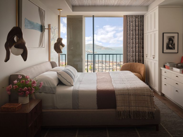 A bedroom with a view of the ocean and a balcony.